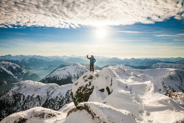 Hiker celebrates after reaching the summit of a mountain