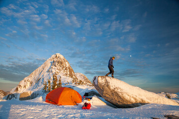 Mountaineer sets up basecamp below a snow covered mountain