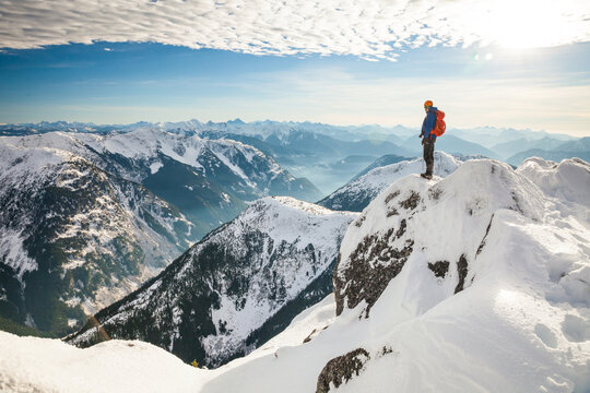 Mountain climber standing on snow covered mountain top