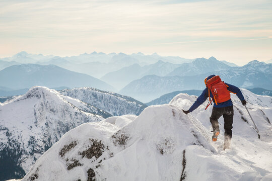 Mountaineer steadies himself with his hand on mountain ridge