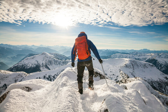 Rear view of mountaineer on snowy cold summit during winter