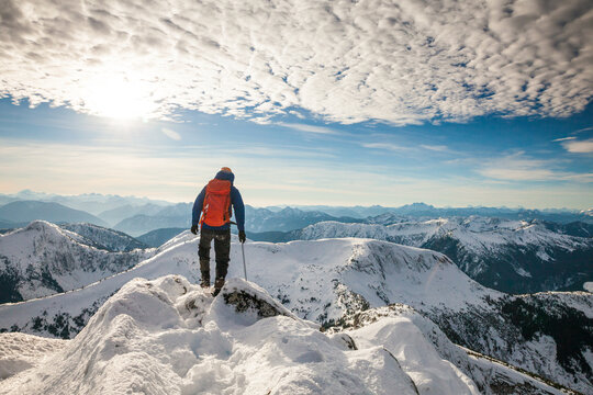 Rear view of successful backpacker standing on mountain summit