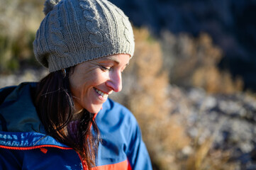 Portrait of a woman smiling in a woollen hat.