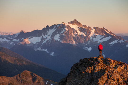 Hiker stands on a rocky ridge in the North Cascade Mountains