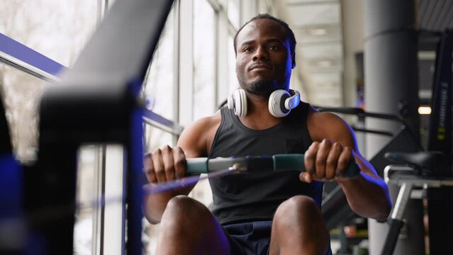 Young black sportsman having workout on rowing machine