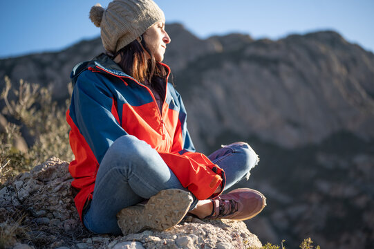 Woman sitting on a rock looking out over the landscape.