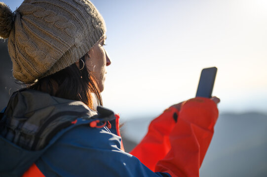 Woman taking a picture of a landscape with a smart phone.