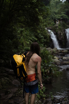 Man traveler with large backpack in tropical jungle of Indonesia. Bali