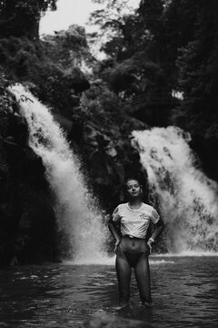 Woman traveler on an adventure at a tropical waterfall, Bali.