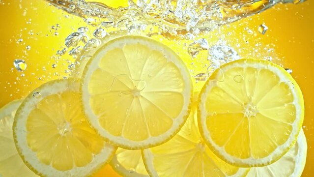 Super Slow Motion Shot of Fresh Lemon Slices Falling and Flowing in Water at 1000 fps.