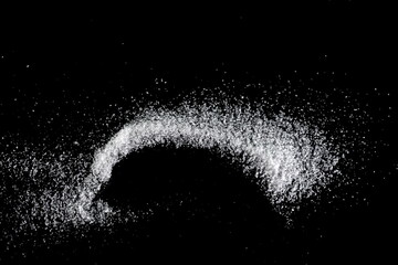 Spilled white sea salt on a black background. clear crystalline pebbles on a black background. Salt...