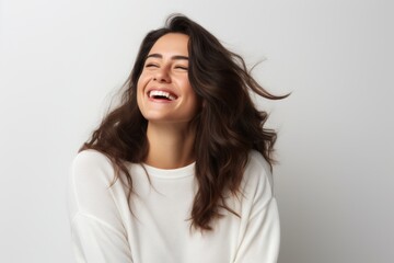 Portrait of a beautiful young woman laughing with closed eyes, white background - obrazy, fototapety, plakaty