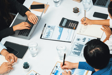 Diverse corporate audit team or company bookkeeper and accountant consultant calculate account expenses and income budget for tax refunds using calculators in busy workspace. Prudent