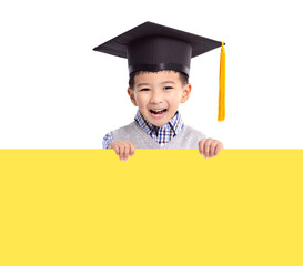 Happy boy in graduation cap and holding with yellow empty banner
