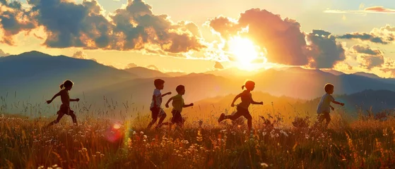 Foto auf Acrylglas A sunset scene of children running on a meadow. © Zaleman
