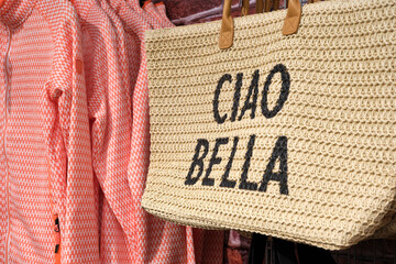 Braided bag with leather handle printed with Italian text Ciao Bella in a boutique. Ciao Bella...