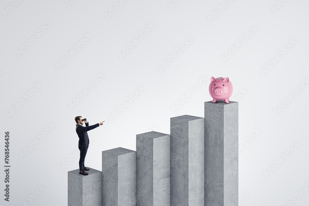 Poster side view of young businessman with binoculars standing on blocks and pointing at piggy bank on ligh