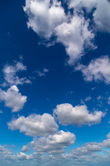 White cumulus clouds on a clear blue sky. - 768551618