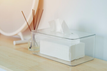 Selective focus of clear plastic box with napkin and mirror, reed diffuser on wooden table
