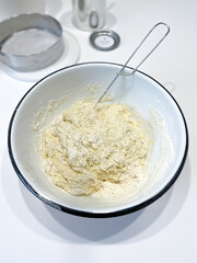 A batterfilled dish with a whisk for mixing ingredients in the kitchen