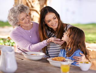 Family, eating or smile in garden for breakfast with love, gathering or bonding with nutrition or wellness. Grandma, mother or child together in backyard or patio in morning for healthy meal or food