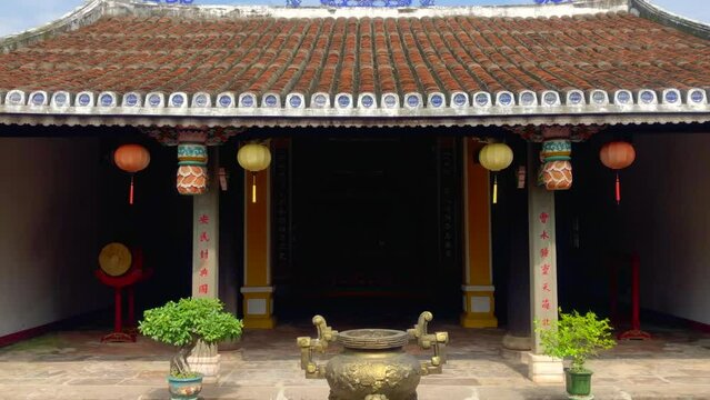 Entrance to a temple. A Buddhist temple with ornaments, lanterns and plants. Ancient town UNESCO World Heritage site. Hoi An, Vietnam.