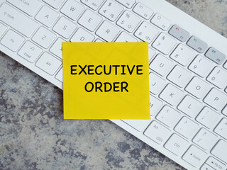 Work and management concept. EXECUTIVE ORDER written on adhesive paper. Blurred styled background.