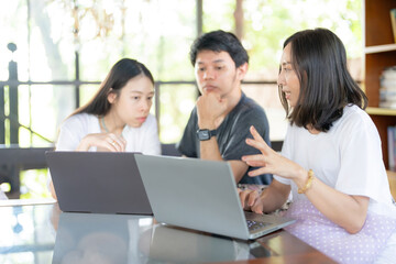 Group of Asian male and female students studying online in university faculty about subject with...
