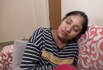 Exhausted Indian Woman Resting on Sofa at Home