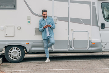 attractive traveler man with caravan and mobile phone - obrazy, fototapety, plakaty