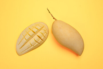 Yellow mango tropical fruit whole sliced cube diced half on yellow background