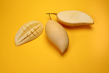 Yellow mango tropical fruit whole sliced cube diced half on yellow background - 768579088