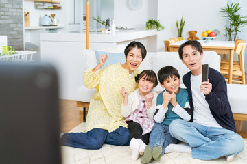 テレビを見ながら応援する4人家族