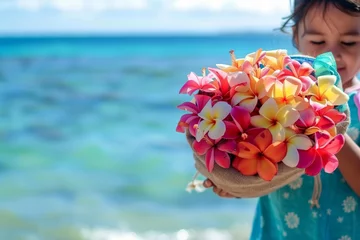 Fotobehang child holding a bag full of vibrant plumerias by the ocean © Alfazet Chronicles