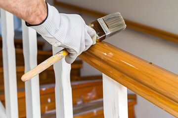painter applying varnish to a wooden handrail