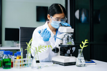 Biologist taking experiment with plants working in biochemistry laboratory.