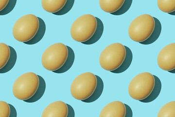 Egg pattern, raw chicken eggs on a blue background. Top view, hatched chick, cracked eggshell, easter concept
