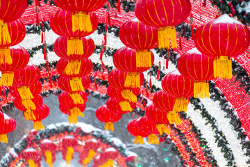 Fototapeta na wymiar Red lanterns in the snow in the park. Chinese New Year holiday