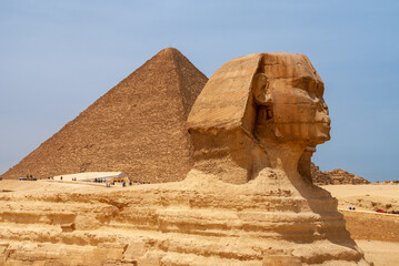 Close-up of Great Sphinx in front of Pyramid of Cheops (Khufu). Giza Pyramid Complex is complex of...
