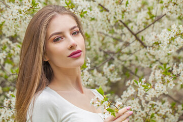 Beauty portrait of young woman with natural makeup and healthy long brown hair in blossom park outdoors. Natural female beauty - 768592861