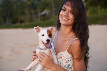 Woman, portrait and dog on beach for relax holiday at sunset for vacation getaway, weekend or bonding. Female person, Jack Russell and face in summer for morning rest in Florida, calm or peaceful