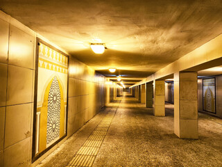 Illuminated Underground Pedestrian Tunnel by Night. A well lit tunnel with columns, leading into...