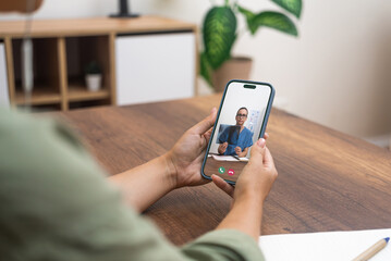 Close-up of a telehealth appointment with a medical professional on a smartphone.