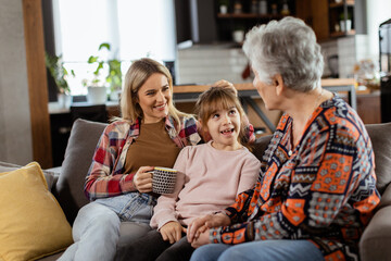 Generational bonding, grandmother, daughter, and grandchild sharing stories on a cozy afternoon - 768598273