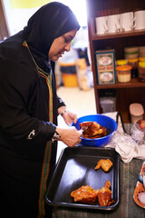 Muslim woman, cooking or food in kitchen for family dinner or malay spice for arabic cuisine. Islam mother or meal preparation of chicken for grill, hijab or islamic tradition or female role in home