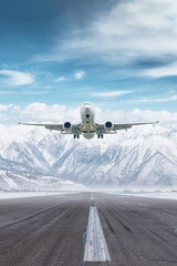 White passenger airplane take off airport runway at winter on the background of high scenic snow...