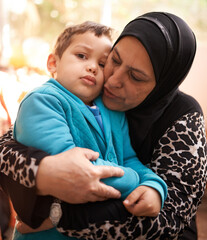 Muslim woman, hug and grandchild in home in portrait, love and bonding together on holiday. Woman,...