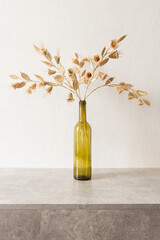 The flowers is made of straw on a white background in an empty bottle. Bouquet of flowers made from...