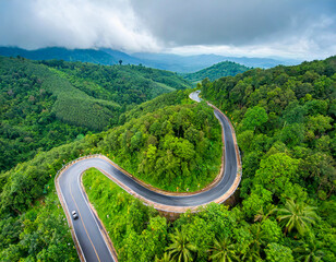 Aerial top view beautiful curve road country on green forest in raining season with sky cloud