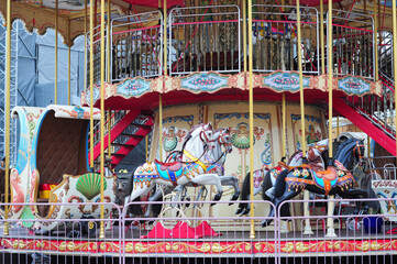 Beautiful white and black horses carousel in a holiday park. Merry-go-round  carrossel with horses.